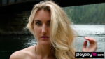 Blonde naked Canadian musician Anna Katarina playing on her guitar outdoor